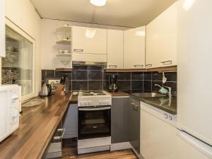 uma cozinha com armários brancos e um forno com placa de fogão em Holiday Home Päivärinne by Interhome em Tallnäs