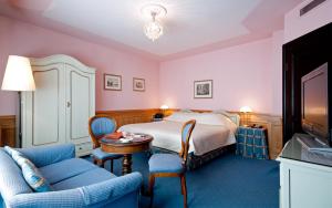 a hotel room with a bed and a table and chairs at Hotel König von Ungarn in Vienna