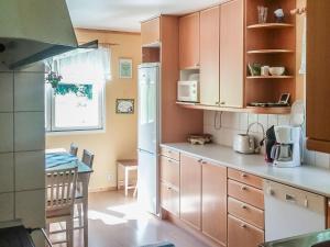 a kitchen with wooden cabinets and a table in it at Holiday Home Långstrands stuga by Interhome in Långstrand