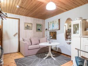 uma sala de estar com um sofá e uma mesa em Holiday Home Puutarhurin mökki by Interhome em Tallnäs