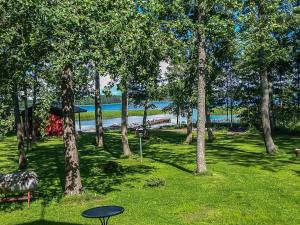 a park with trees and a table in the grass at Holiday Home Långstrands stuga by Interhome in Långstrand