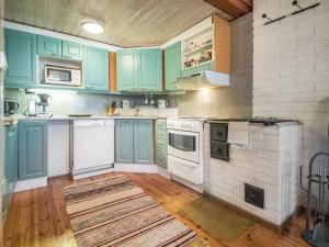 a kitchen with blue cabinets and white appliances at Holiday Home Lohjanherra by Interhome in Tallnäs