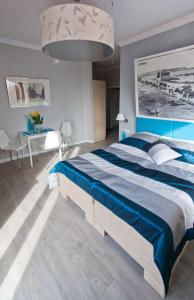 Un dormitorio con una cama azul y blanca y una mesa en Pokoje i Apartamenty Retro Gdynia, en Gdynia