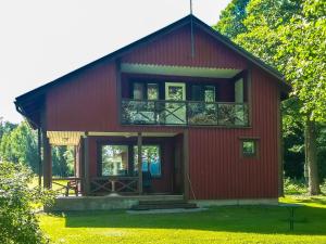 a red house with a balcony on top of it at Holiday Home Långstrands stuga by Interhome in Långstrand