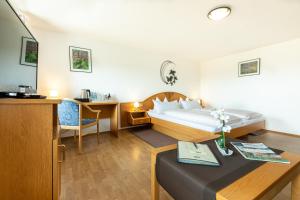 シュタイネンにあるHotel Landgasthof zum Pflugのベッドとテーブルが備わるホテルルームです。