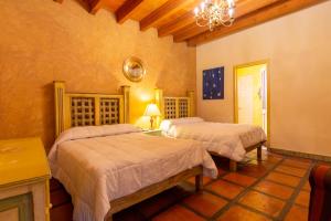 a bedroom with two beds and a chandelier at Casa Magica in Guanajuato