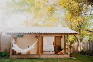 a small house with a bed in a backyard at Casa Pitanga - Caraíva in Caraíva