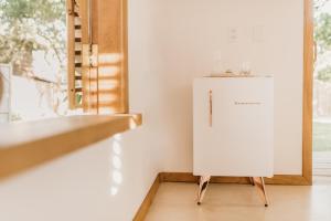 a white refrigerator in a room with a window at Casa Pitanga - Caraíva in Caraíva
