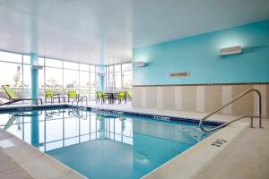 a swimming pool with tables and chairs in a building at SpringHill Suites by Marriott Springfield North in Springfield