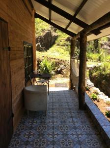 une terrasse couverte d'une maison avec une baignoire et une table dans l'établissement Unique Tiny House with Natural Building Techniques, à Figueiró dos Vinhos