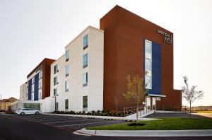 a building with a car parked in a parking lot at SpringHill Suites by Marriott Springfield North in Springfield