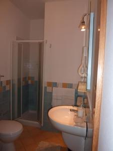 uma casa de banho com um lavatório, um chuveiro e um WC. em La Prua D'Amare em Ustica