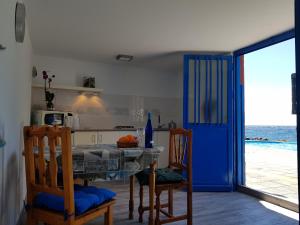 una cucina con tavolo, sedie e porta blu di Sueño de Mar a Güímar
