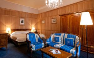 a hotel room with two chairs and a bed at Hotel König von Ungarn in Vienna
