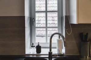 um lavatório de cozinha com uma janela por cima de um lavatório em Hissla Riquewihr Le Schlupf & La Perle em Riquewihr