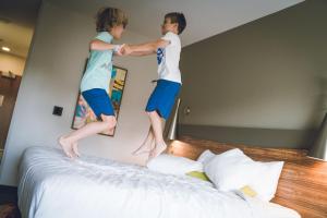 dos jóvenes saltando sobre una cama en The Kartrite Resort and Indoor Waterpark, en Monticello