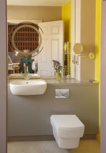 a bathroom with a sink and a toilet and a mirror at Armada Hotel in Spanish Point