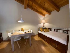 1 dormitorio con 1 cama, mesa y sillas en Avet, El Tarter, Zona Grandvalira, en El Tarter