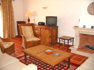 uma sala de estar com TV e lareira em Holiday Home Praia del Rey Golf by Interhome em Praia del Rei