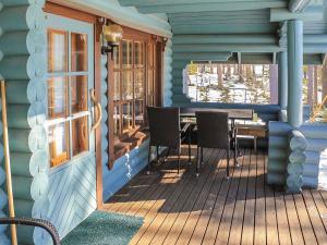 ein blaues Haus mit einem Tisch und Stühlen auf der Veranda in der Unterkunft Holiday Home Marjaranta by Interhome in Konnevesi