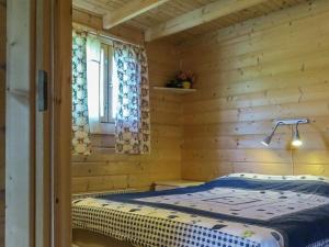 a bedroom with a bed in a log cabin at Holiday Home Tuisku by Interhome in Punkalaidun