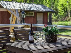 HaraにあるHoliday Home Kytöranta by Interhomeの木製テーブルにワイン1本とグラス2杯