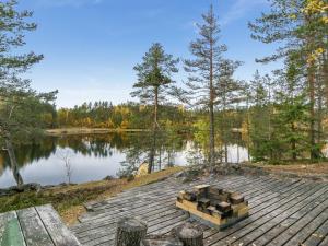 a picnic table on a dock next to a lake at Holiday Home Harrila by Interhome in Huuhanaho