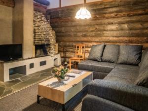 a living room with a couch and a fireplace at Holiday Home Vuokatinportti a7 by Interhome in Lahdenperä