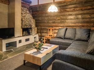 ein Wohnzimmer mit Couch und Kamin in der Unterkunft Holiday Home Vuokatinportti a7 by Interhome in Lahdenperä