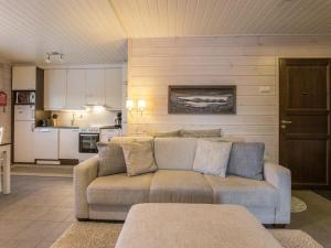 ein Wohnzimmer mit einem Sofa und einer Küche in der Unterkunft Holiday Home Hil-lak-ka ii as 7 by Interhome in Äkäslompolo