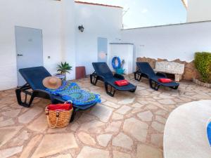 un patio con sillas azules y suelo de piedra en Villa Rustical Mont Roig by Interhome en Miami Platja