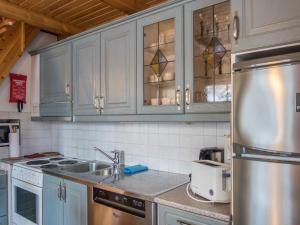 a kitchen with white cabinets and a stainless steel refrigerator at Holiday Home Vaarapirtti - tähti by Interhome in Lahdenperä