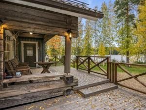 a porch of a cabin with a table and a fence at Holiday Home Talasniemi by Interhome in Hara