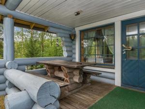 a porch with a wooden table and a blue door at Holiday Home Harrila by Interhome in Huuhanaho