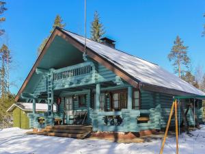 ein grünes Haus mit einem Gamer-Dach im Schnee in der Unterkunft Holiday Home Marjaranta by Interhome in Konnevesi