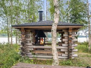 a log cabin with a chimney on top of it at Holiday Home Talasniemi by Interhome in Hara
