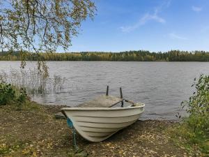 un barco sentado en la orilla de un lago en Holiday Home Kytöranta by Interhome, en Hara