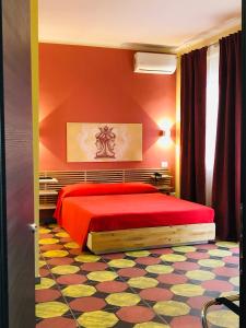 een slaapkamer met een rood bed en een kleurrijke vloer bij villa oltremare resort in Bagheria