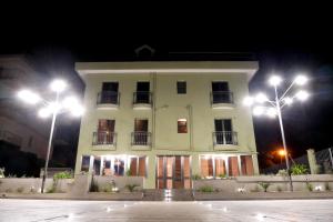 - un grand bâtiment blanc avec des lumières devant dans l'établissement villa oltremare resort, à Bagheria