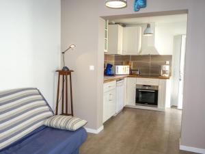 グジャン・メストラにあるHoliday Home La Hume by Interhomeの白いキャビネットと青いソファ付きのキッチンが備わります。