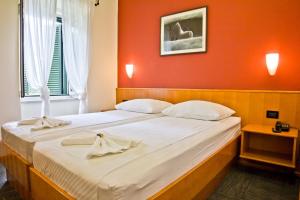 a bedroom with a large bed with a red wall at Hotel Kastil in Bol