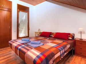 a bedroom with a large bed with red and blue pillows at Holiday Home Paradis by Interhome in Mont Barbat