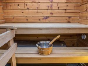 un cubo con una cuchara de madera en una sauna en Holiday Home Rukantaika 1b by Interhome en Virkkula