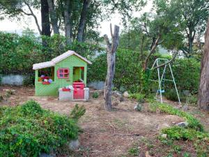 a small green shed with a playground in a yard at Holiday Home Paradis by Interhome in Mont Barbat