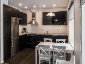 a kitchen with black cabinets and a white counter top at Holiday Home Klz rodoniitti by Interhome in Vuokatti
