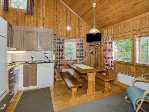 a kitchen with wooden walls and wooden floors and a wooden table at Holiday Home Kanerva by Interhome in Ahmovaara +15 photos