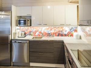a kitchen with white cabinets and stainless steel appliances at Holiday Home Maaruska a by Interhome in Äkäslompolo