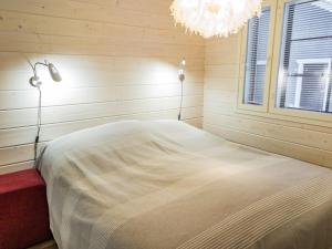 Schlafzimmer mit einem Bett und einem Kronleuchter in der Unterkunft Holiday Home Maaruska a by Interhome in Äkäslompolo