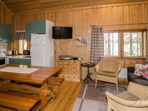 uma cozinha e sala de estar com uma mesa e um sofá em Holiday Home Metsätähti by Interhome em Ahmovaara