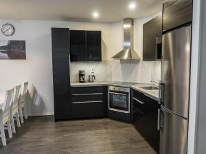 a kitchen with black cabinets and a stainless steel refrigerator at Holiday Home Klz krysoliitti by Interhome in Vuokatti